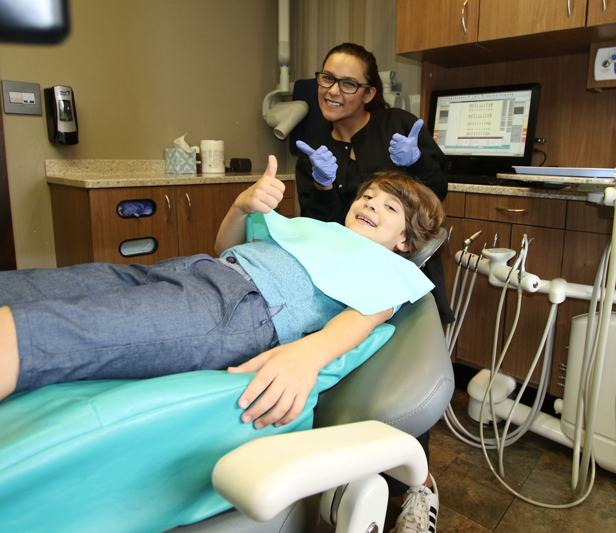 Kid giving thumbs up after a dental exam at Grins and Giggles Family Dentistry in Spokane Valley, WA