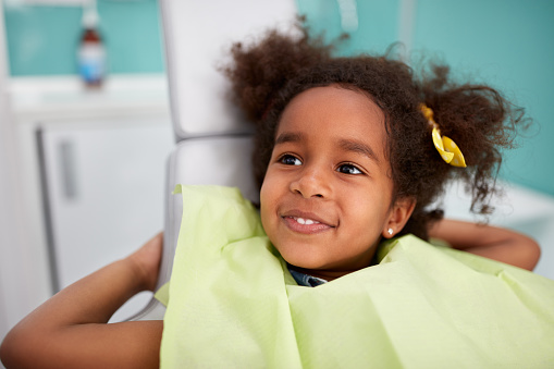 Young girl smiling in dental chair after dental cleaning and exam at Grins & Giggles Family Dentistry in Spokane Valley, WA 