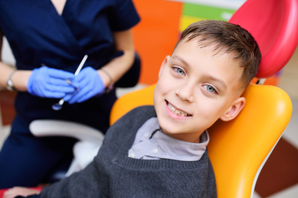 Young boy sitting in dental chair and smiling at Grins and Giggles Family Dentistry in Spokane Valley, WA