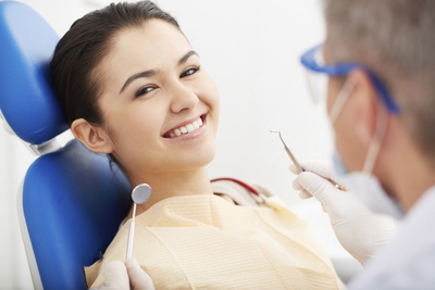 Woman in dental chair smiling while having a dental exam at Grins & Giggles Family Dentistry in Spokane Valley, WA